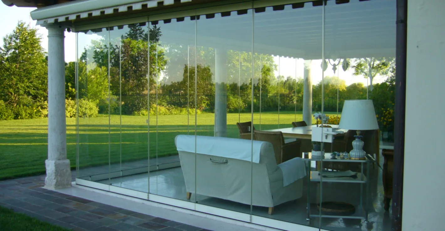 Преобразите веранду в стильную и многофункциональную зону с безрамным остеклением.