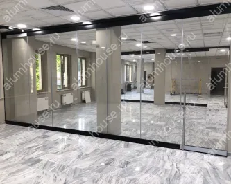 Безрамные раздвижные стеклянные перегородки в офисе