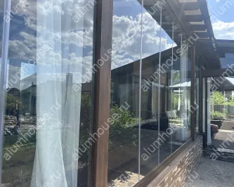 Безрамное остекление веранды системой книжка