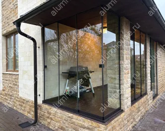 Безрамное раздвижное остекление веранды со стеклянным углом