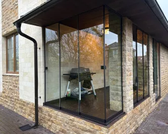 Безрамное раздвижное остекление веранды со стеклянным углом