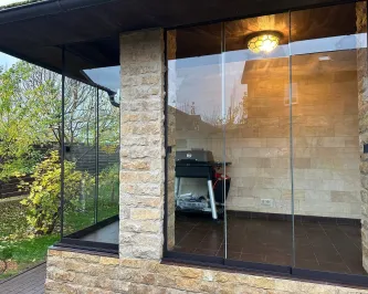 Безрамное раздвижное остекление веранды со стеклянным углом