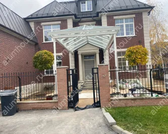 Большой стеклянный навес над входом частного дома