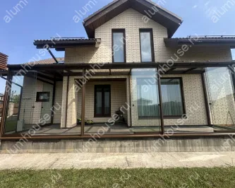 Веранда к дому со стеклянной крышей и безрамным остеклением