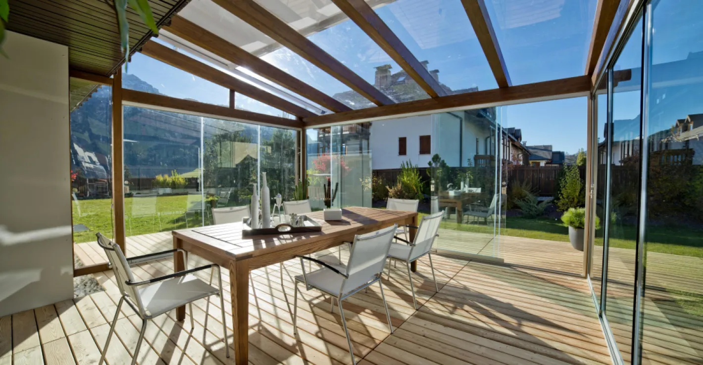 Стеклянная крыша визуально расширяет пространство веранды, сохраняя защищённость.