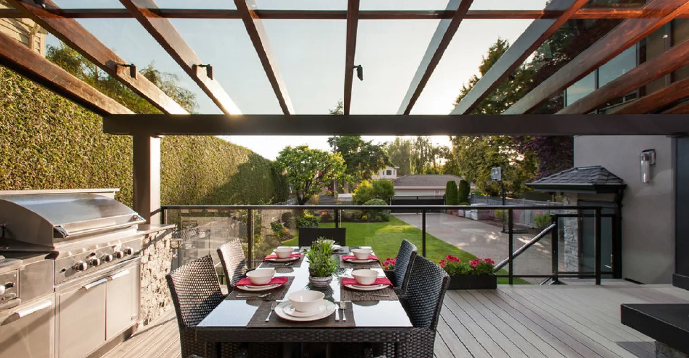 Современный стеклянный навес поддерживает чистоту и комфорт на барбекю-площадке круглый год.