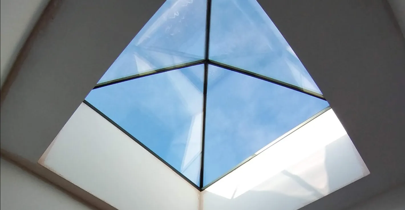 Стеклянная крыша‑пирамида подчёркивает геометрию и современный стиль.