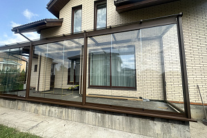veranda-k-domu-so-steklyannoy-kryshey-i-bezramnym-ostekleniem