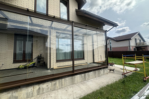 veranda-k-domu-so-steklyannoy-kryshey-i-bezramnym-ostekleniem